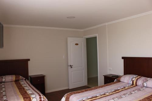 a room with two beds and a door in it at Alto El Quisco in El Quisco