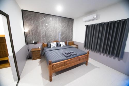 ein Schlafzimmer mit einem Bett und einem großen Fenster in der Unterkunft บ้านคุณ เฮ้าส์ in Phrae