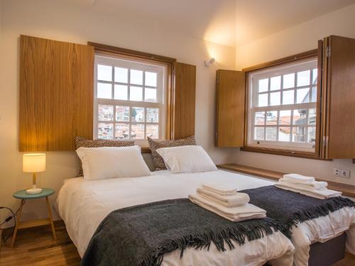 een slaapkamer met een bed met handdoeken erop bij Belomont6 Apartments in Porto