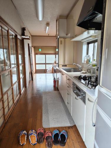 a kitchen with a bunch of shoes on the floor at Walkable retro town , Supermarkets nearby,高野口ガッコーチカクのゲストハウス in Hashimoto