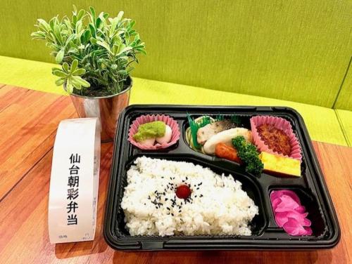 a tray of food with rice and vegetables on a table at HOTEL LiVEMAX Sendai Kokubuncho in Sendai