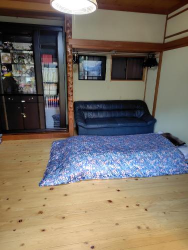 a bedroom with a couch and a blue bed at 町中ステイ 宗ハウス in Nachikatsuura