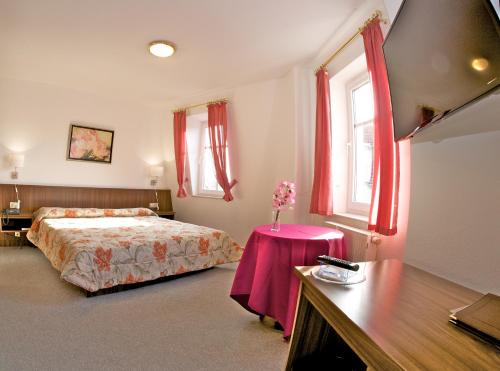 a bedroom with a bed and a table with flowers on it at Hotel Weberhof in Zittau