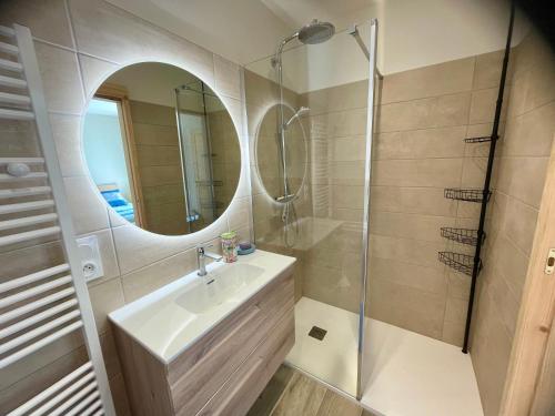 a bathroom with a sink and a shower and a mirror at Le temps des Pins in La Teste-de-Buch
