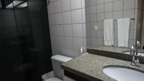 y baño con lavabo, aseo y espejo. en Via Venneto Flat, en Fortaleza