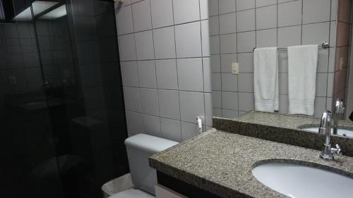 a bathroom with a sink and a toilet and a mirror at Via Venetto Flat - no melhor bairro de Fortaleza in Fortaleza