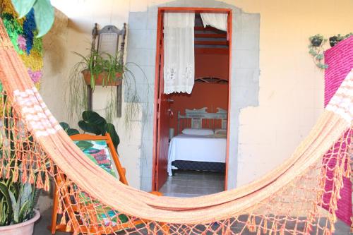 a hammock in a room with a bedroom at Pousada Peregrino in Barra de Jacuípe
