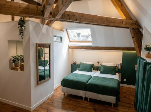 a bedroom with two beds with green pillows at Maison Maubert in Thiers
