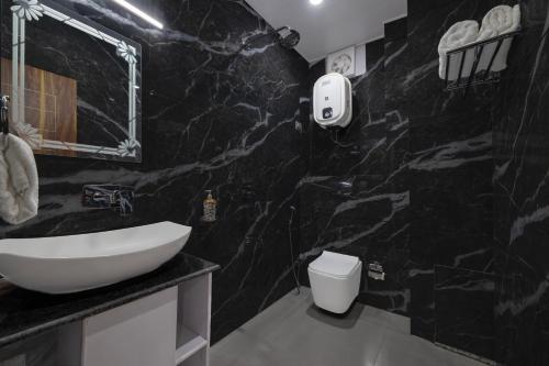 a black marble bathroom with a sink and a toilet at Sunrise Villa in Fagu