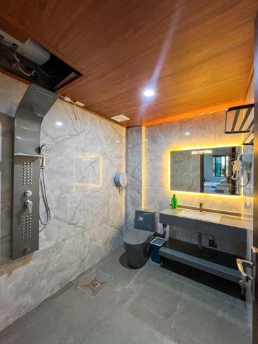 a bathroom with a shower and a toilet and a sink at Tam Coc Victoria Hotel in Ninh Binh