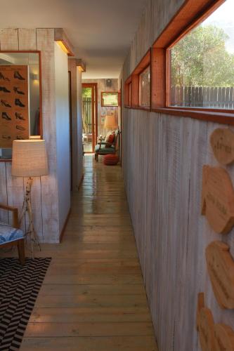 a hallway of a house with wooden floors and windows at Casapapudo Boutique Home in Papudo