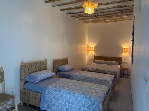 a room with three beds and a ceiling with lights at Darnamed in Nador