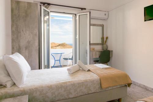 a bedroom with a bed with a view of the ocean at Panorama Rooms in Anafi