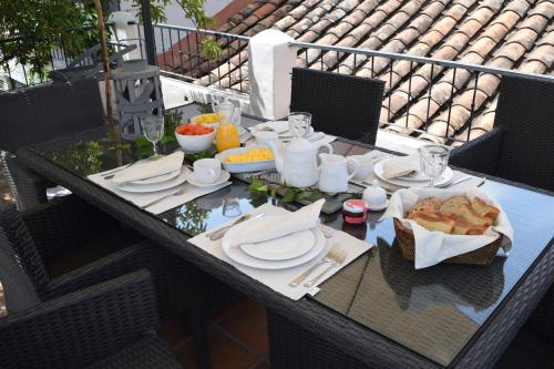 einen Tisch mit Tellern aus Essen auf einem Balkon in der Unterkunft Hotel MasClara in Villa de Leyva