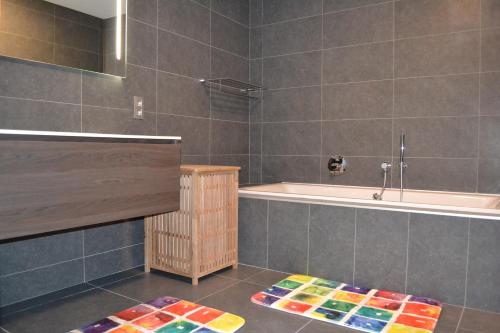 łazienka z wanną i dywanem w obiekcie Gîtes Paquay w mieście Libramont
