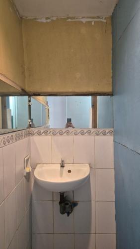 a bathroom with a sink and a mirror at Lucy's Diner Hostel Cafe in San Francisco