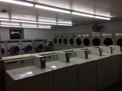 a laundry room with a row of washers and dryers at Ranch House Inn & Suites in Temple