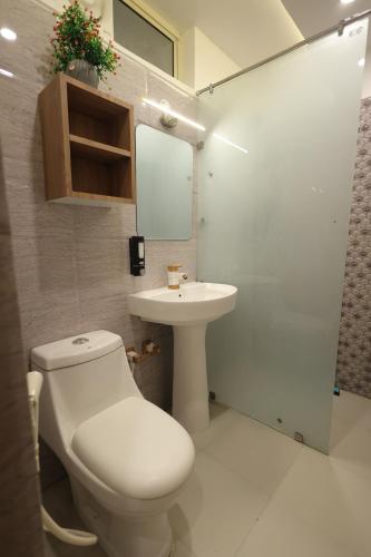 a bathroom with a white toilet and a sink at Navrasa By CDF in Vrindāvan