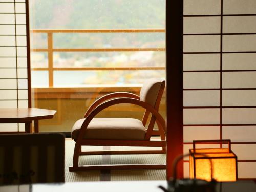 a chair sitting in front of a window at Kasuitei Ooya in Fujikawaguchiko