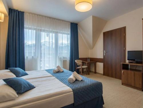 a bedroom with a large bed with towels on it at Pensjonat pod Kotelnicą in Białka Tatrzańska