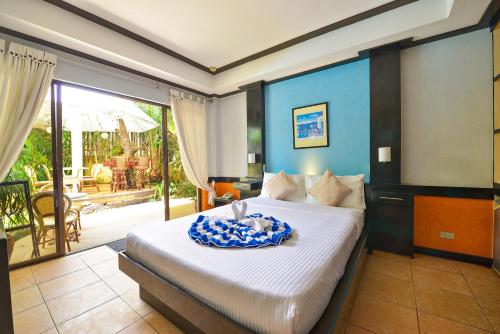 um quarto com uma cama grande e uma varanda em Villa Sunset Boracay em Boracay