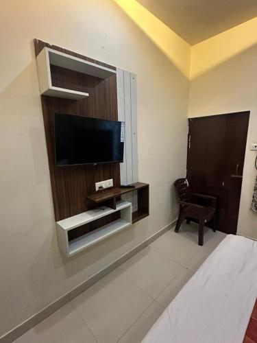 a living room with a flat screen tv on a wall at Hotel Lake View in Varanasi