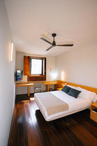 a bedroom with a large white bed and a desk at Hostatgeria de Poblet in Poblet