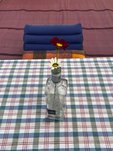 a vase with a flower in it on a table at Ponko Home in Ban Si Than
