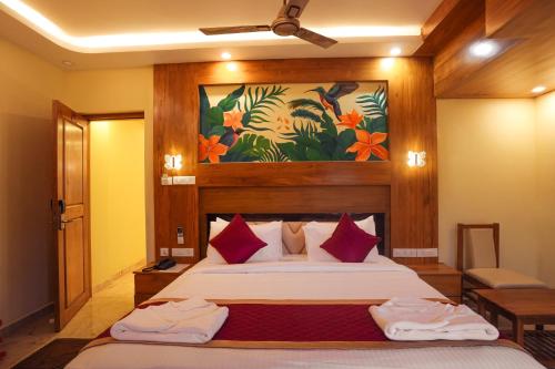 a bedroom with a bed and a painting on the wall at Le Kumar Residency in Pondicherry