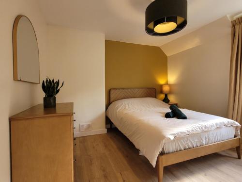 a bedroom with a bed and a dresser with a lamp at Riverside Home Kinlochleven in Kinlochleven