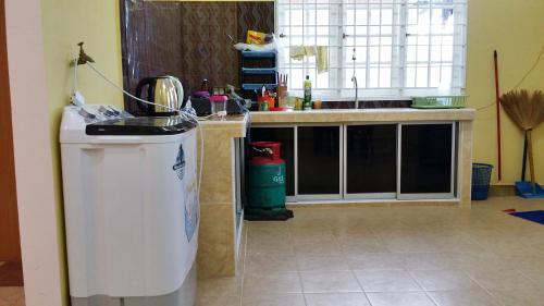 a kitchen with a sink and a trash can at Noor Guesthouse in Kampong Alor Ganu