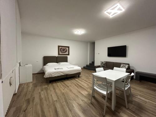 a room with a bed and a table and a bed and a tv at Grelios stanze preziose in Guardiagrele