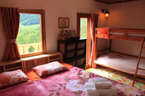 a bedroom with two bunk beds and a window at Winterfell Hakuba in Hakuba