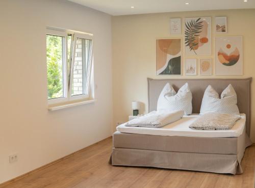 ein Schlafzimmer mit Bett, weißen Wänden und einem Fenster in der Unterkunft Finca Berlin nähe Olympiastadion in Berlin