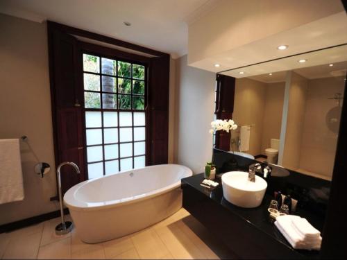 a large bathroom with a large tub and a sink at Meerendal Boutique Hotel in Durbanville