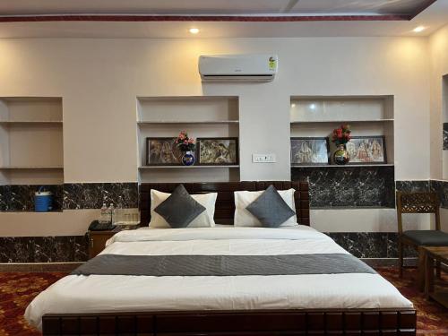 a bedroom with a large bed and shelves at Hotel Srinivas in Jodhpur
