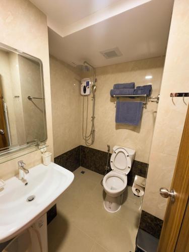 a bathroom with a white toilet and a sink at Mai Khao 777 Beach Condo in Ban Mai Salae