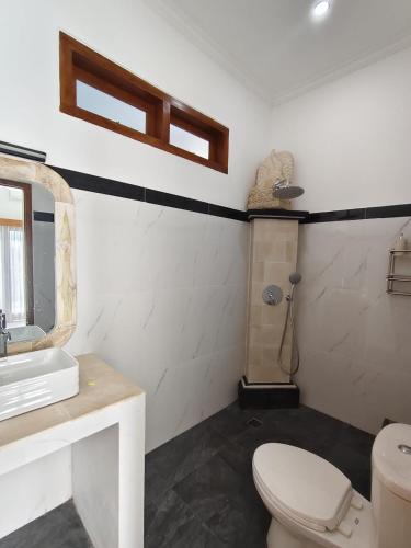a bathroom with a toilet and a sink at Villa Bagus in Lovina