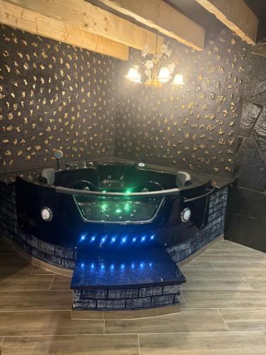 a bathroom with a green tub with blue lights at Refúgio Muas Nature in Vila Real