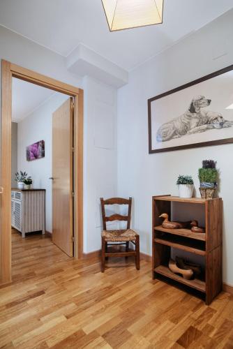 a living room with a chair and a wooden floor at Gaudioso by Cardi Suites in Sallent de Gállego