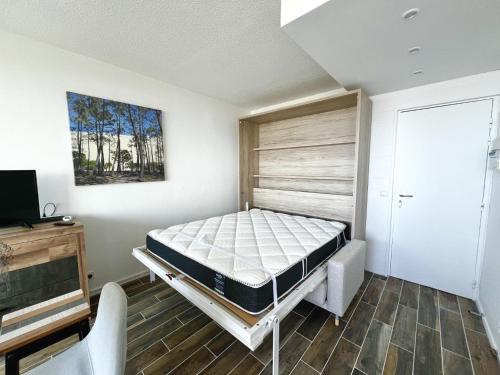 a bedroom with a bed and a tv in it at Oceanide 72 by agence bru in Lacanau-Océan