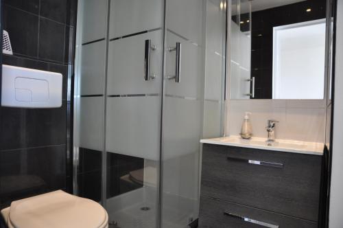 a bathroom with a shower and a toilet and a sink at Oceanide 72 by agence bru in Lacanau-Océan
