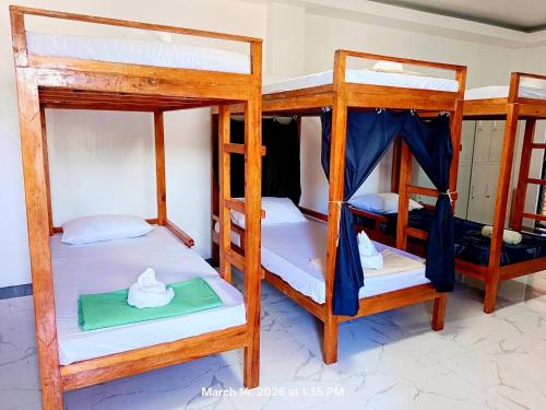 a room with three bunk beds in a house at Chief's Villa Malapascua Island Dorm with Hot Shower & Outdoor Kitchenette in Malapascua Island