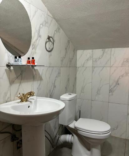 ein Badezimmer mit Waschbecken, Toilette und Spiegel in der Unterkunft pars otel in Tuzla