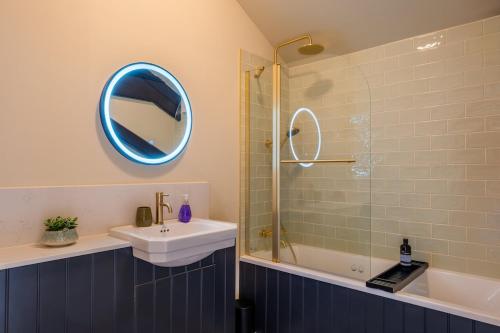 a bathroom with a sink and a shower with a mirror at Luxury Riverside Duplex Apartment for 4 in Wilton