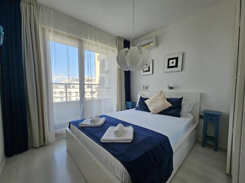 a bedroom with a bed with two towels on it at Aпартаменти Хоризонт in Sozopol