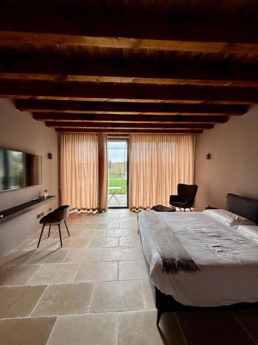 a bedroom with a large bed and a large window at Dimora Rosaspina Suite Eden e Suite Platinum in Adro