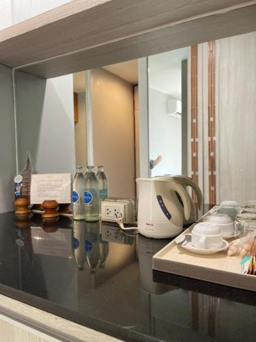 a glass counter top with a toaster and a reflection in a mirror at Sukhothai Treasure Resort & Spa in Sukhothai