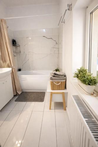 a bathroom with a tub and a toilet and a stool at Apartament Salina Turda in Turda