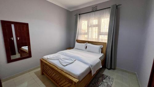 a small bedroom with a bed and a window at Dolphin AIR B&B in Arusha